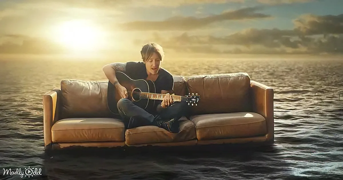 A person plays guitar on a floating couch in a serene, sunlit water scene.