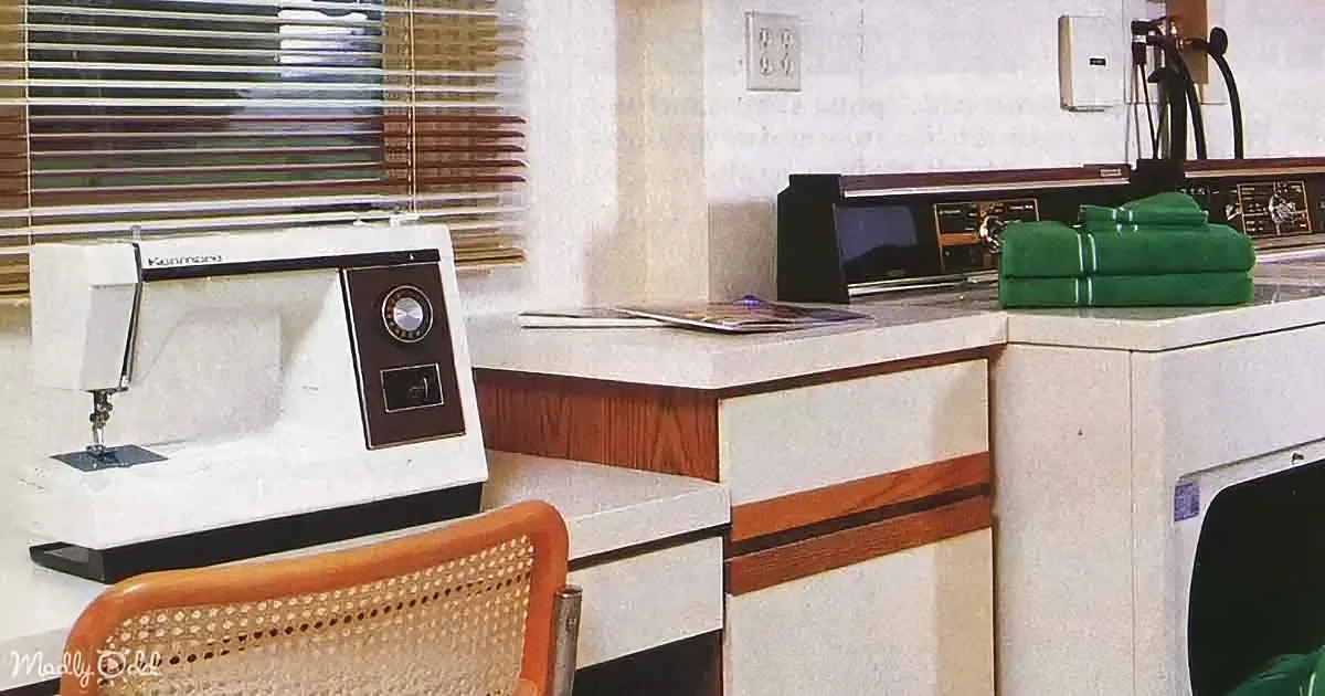 A vintage Kenmore sewing machine sits on a counter next to a green towel and a washing machine.
