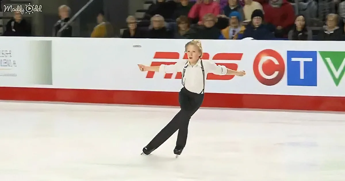 A young figure skater in a white shirt and black pants glides gracefully on ice.