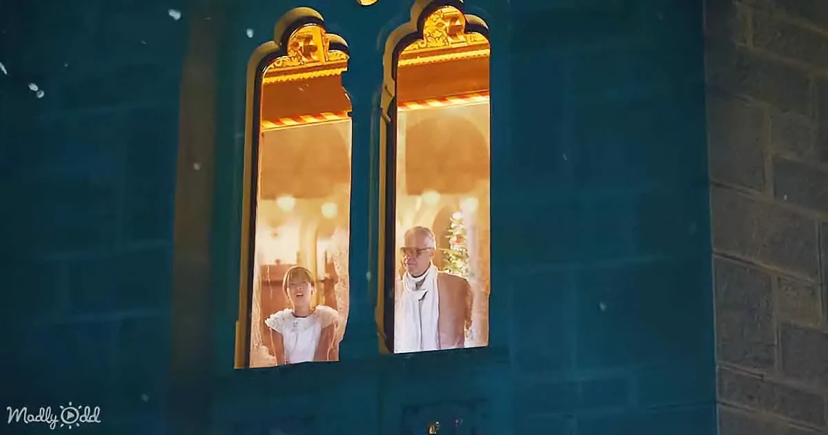 A man and a child are seen through a window, with the man wearing a scarf and the child in a white dress, surrounded by...