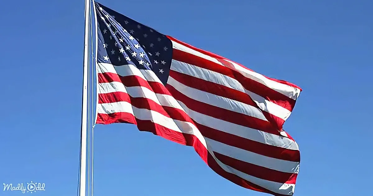 A waving American flag against a clear blue sky.