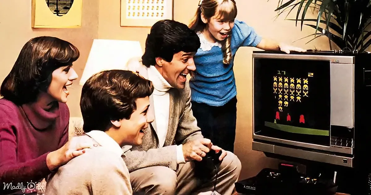 A family is gathered around a TV, playing a classic video game, laughing and enjoying the moment.