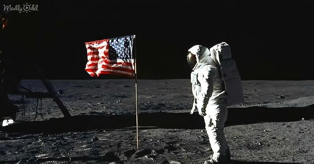 An astronaut stands beside an American flag on the moon's surface.