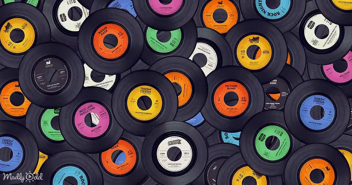 A collection of vintage vinyl records with colorful labels and various text, densely stacked.