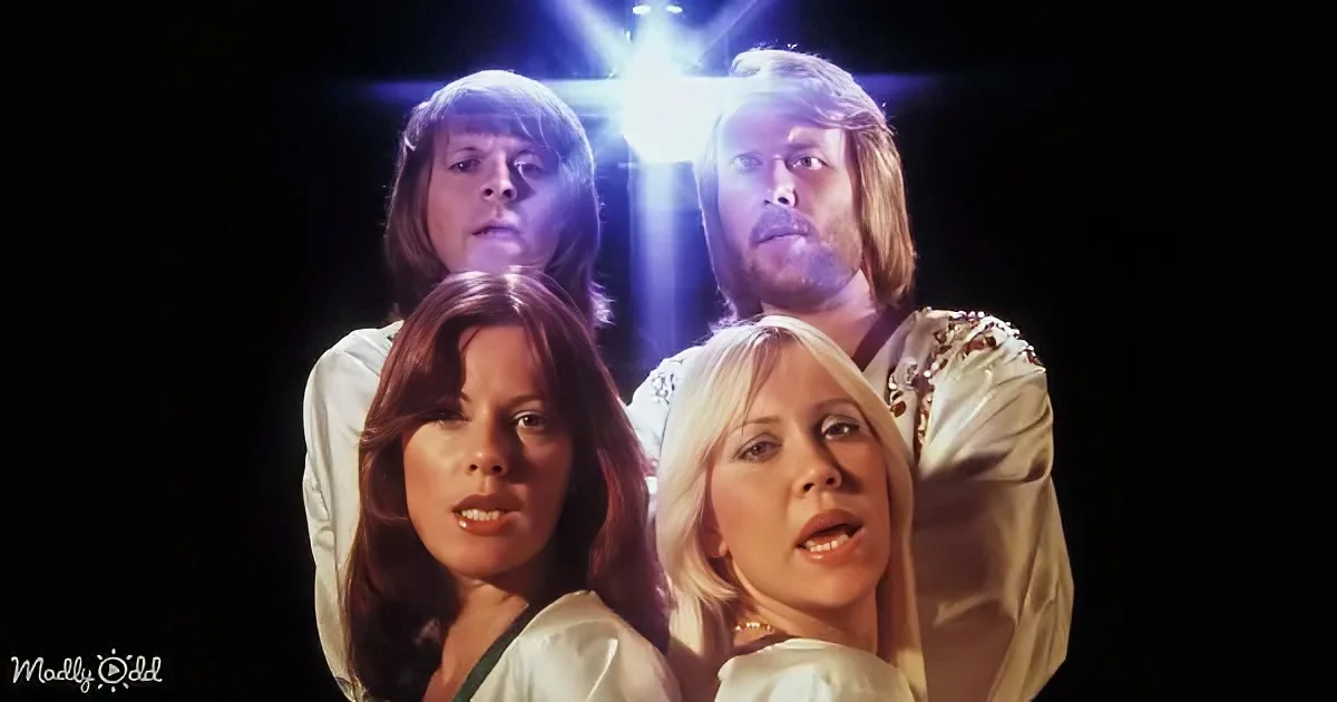 Four individuals in white attire, one with a bright light behind, against a dark background.