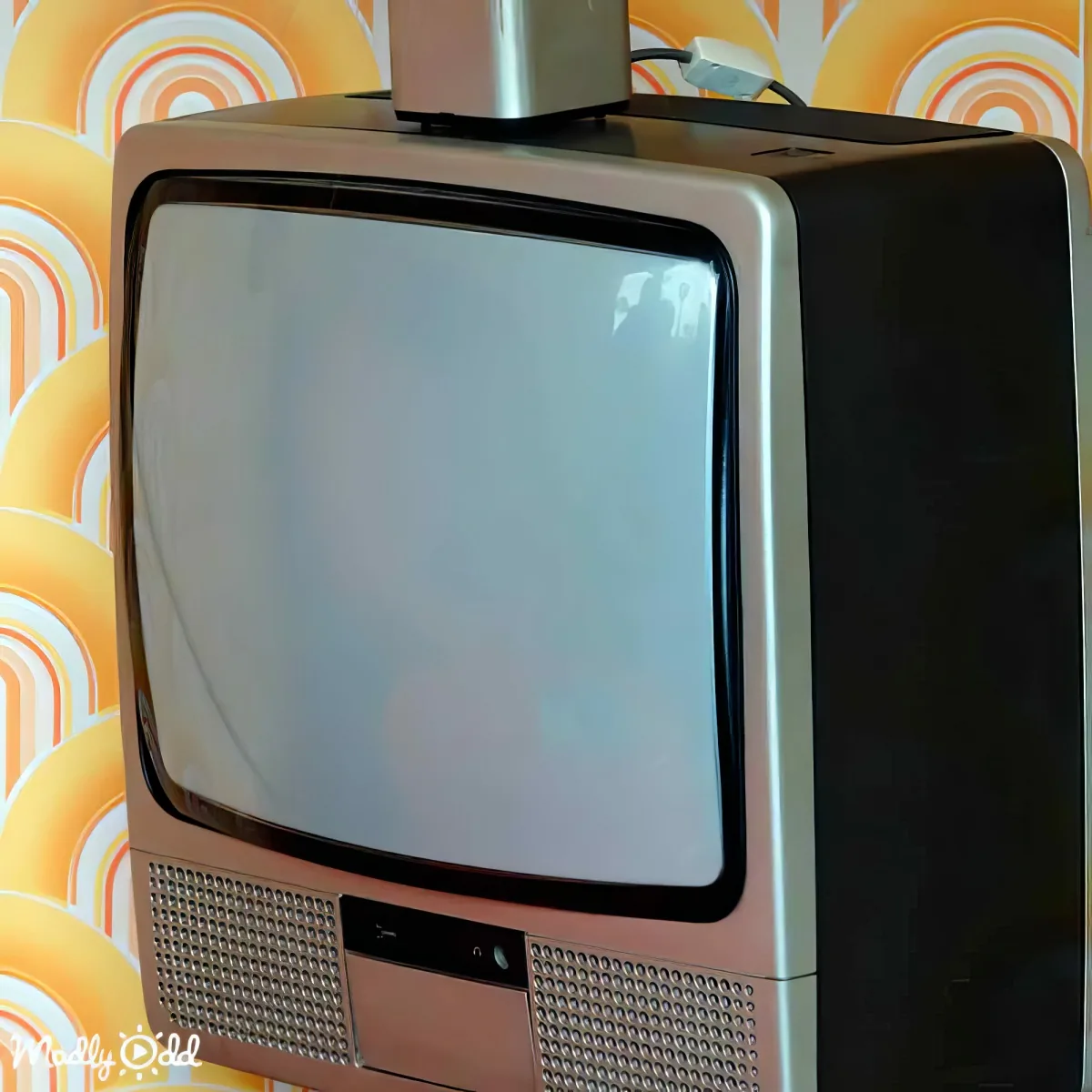 An old-fashioned television set with a blank screen sits against a vibrant, retro-patterned background.