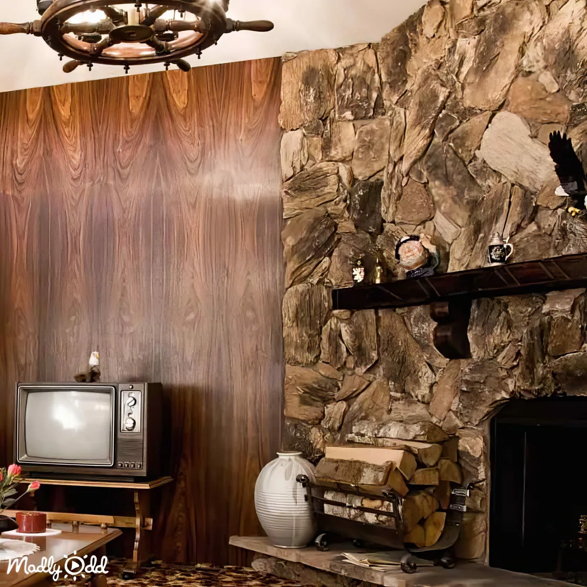 A vintage living room features a stone fireplace, wooden paneling, and a retro TV on a wooden stand.