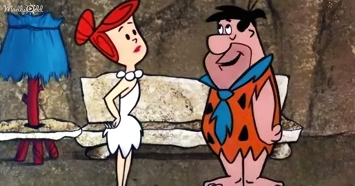 Fred and Wilma are sitting on a stone bench, Fred smiling, Wilma looking concerned.