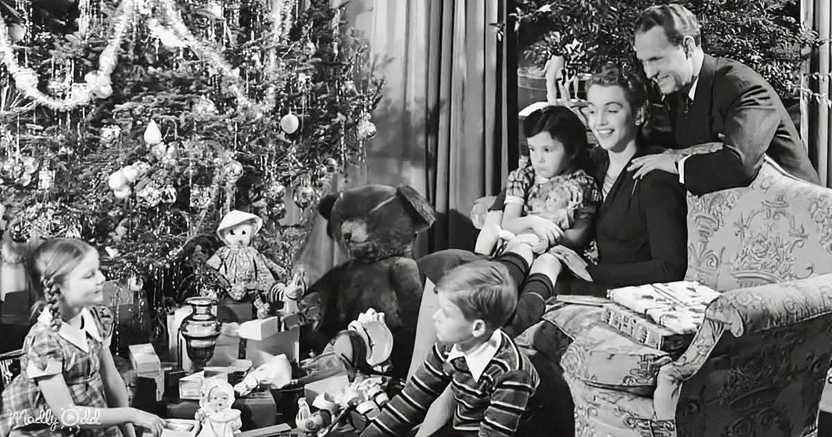 A family gathers around a Christmas tree, exchanging gifts and smiling, with a large teddy bear as a centerpiece.