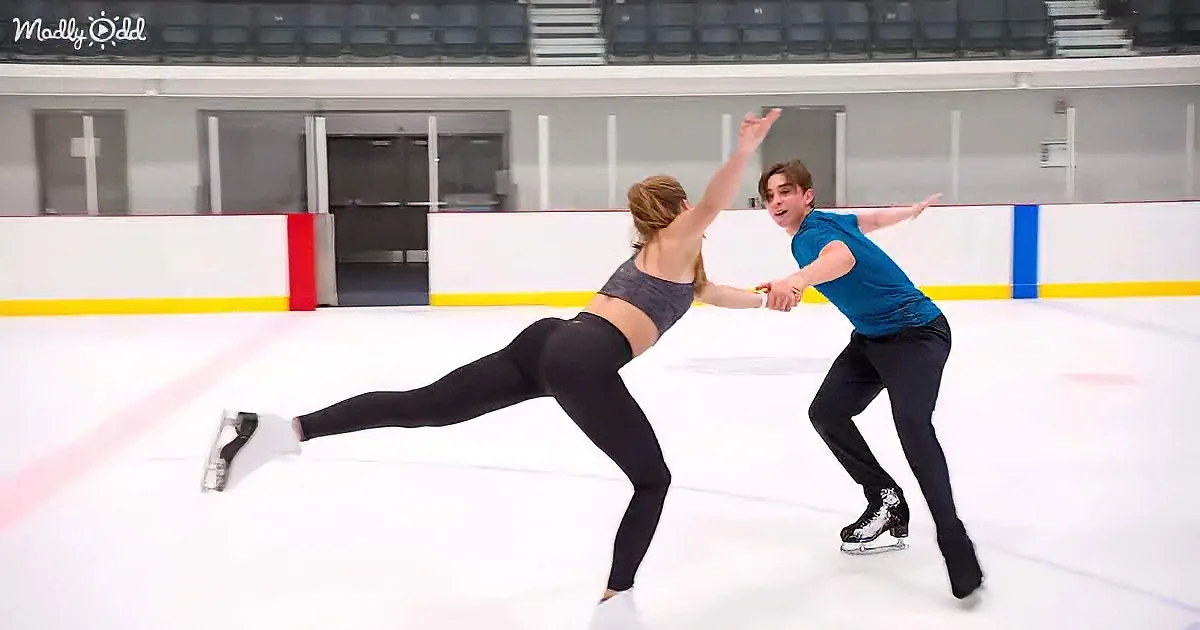 A man and woman are skating together on an ice rink, performing a synchronized move.