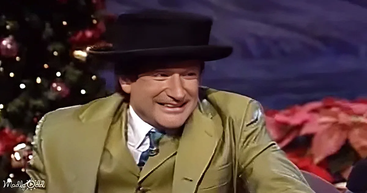 A man in a green suit and black hat smiles, with a Christmas tree and decorations in the background.