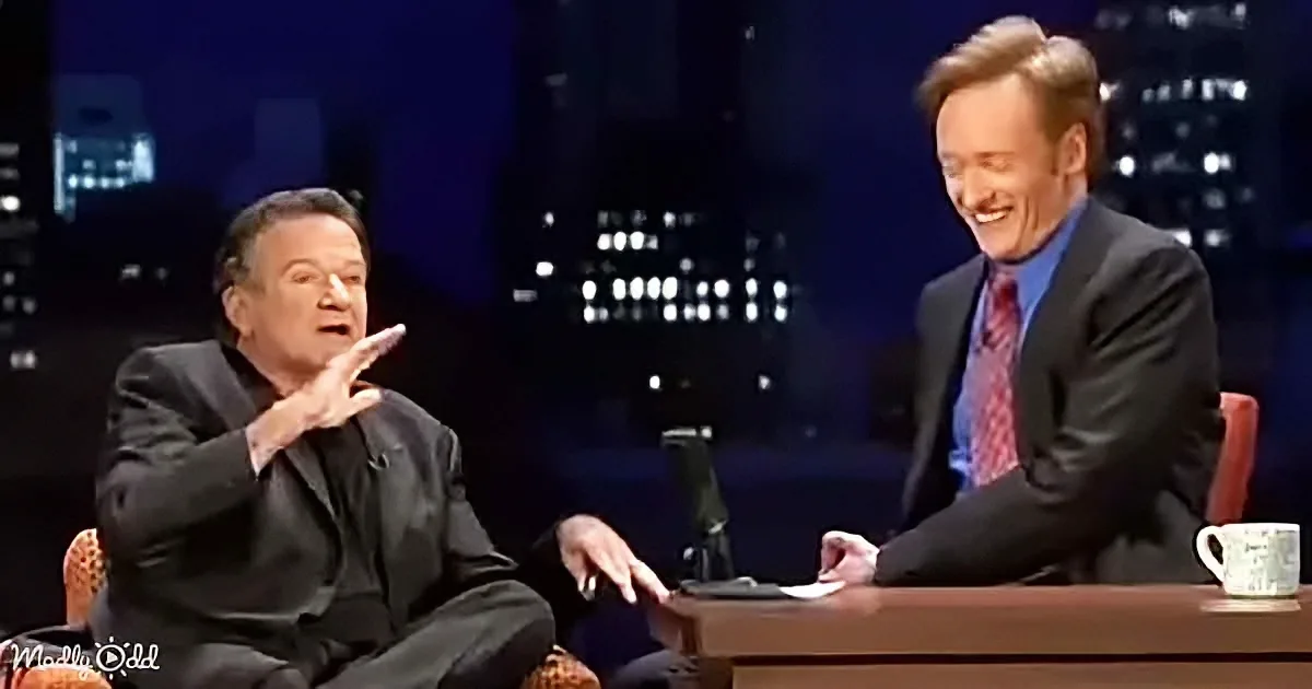 Robin Williams gestures animatedly while Conan O'Brien smiles during a talk show.