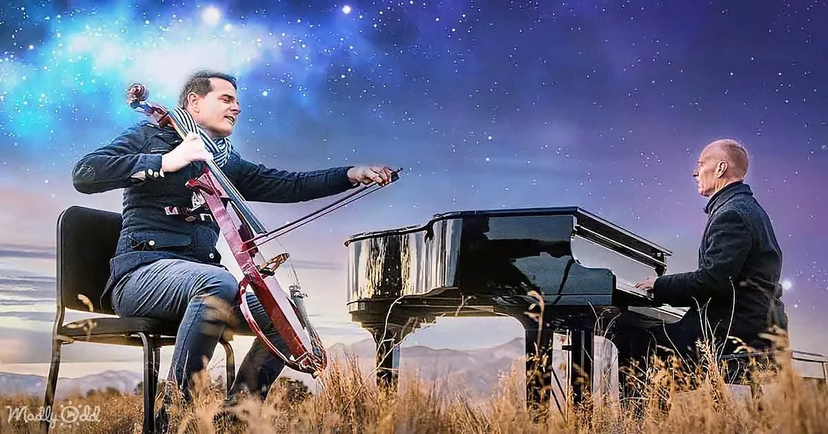 A man plays cello while another plays piano under a starry sky.