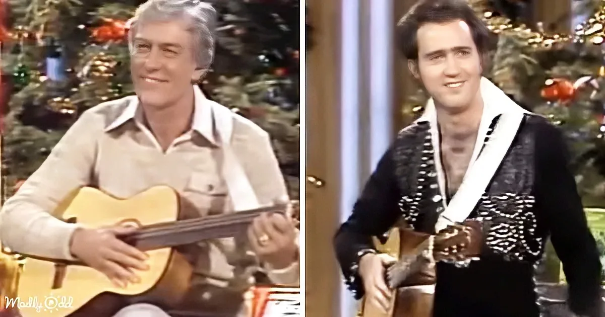 A man in a beige shirt plays a guitar, another in a black and white outfit also plays a guitar.