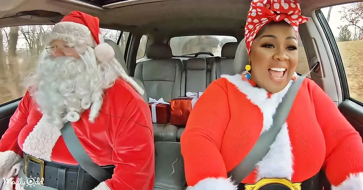 A person dressed as Santa Claus and another in a festive outfit are driving in a car, smiling and enjoying the moment.