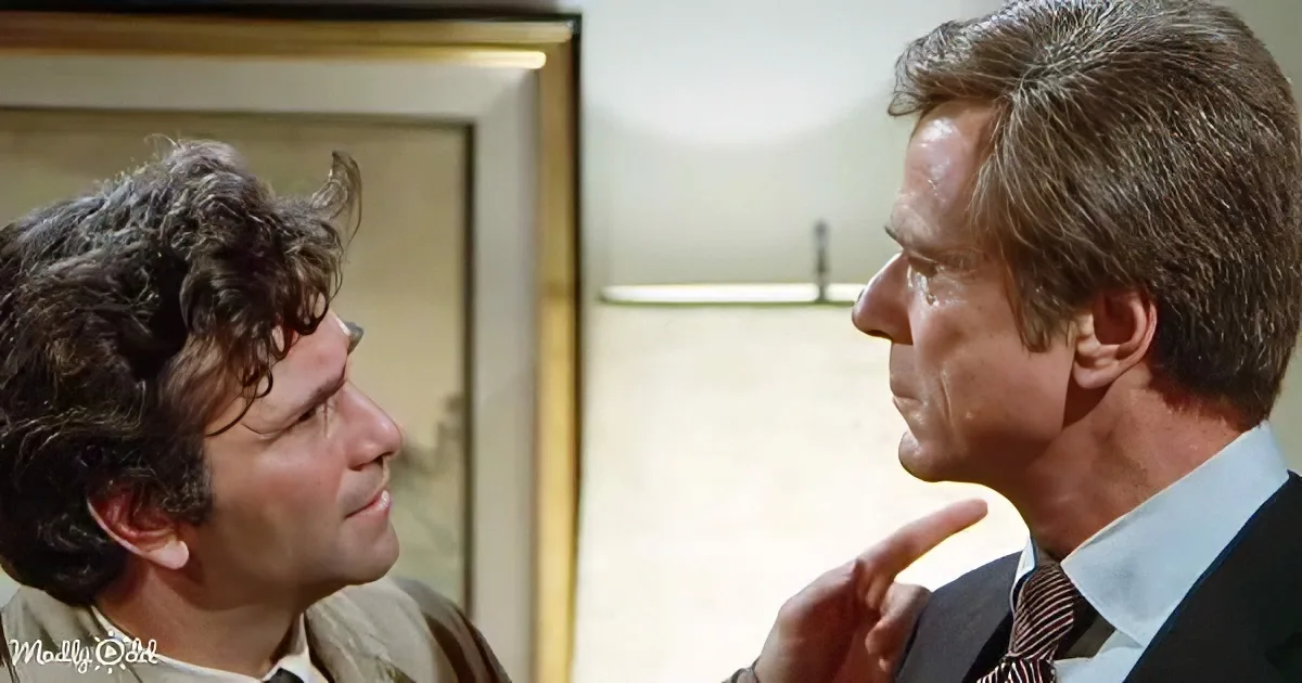 A man in a suit points at another man with curly hair in a tense moment.