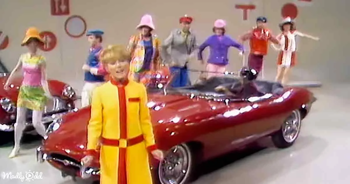 A person in a yellow outfit stands in front of a red convertible car, surrounded by other colorful figures.
