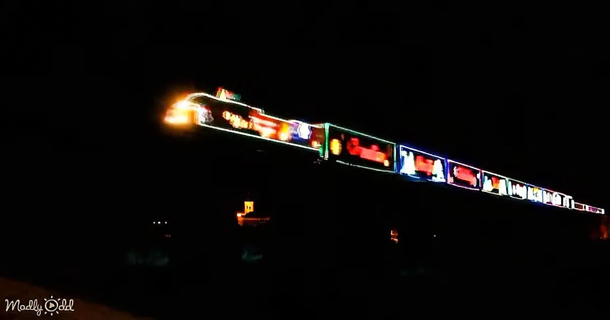 A brightly lit train moves through the night, leaving a trail of light.