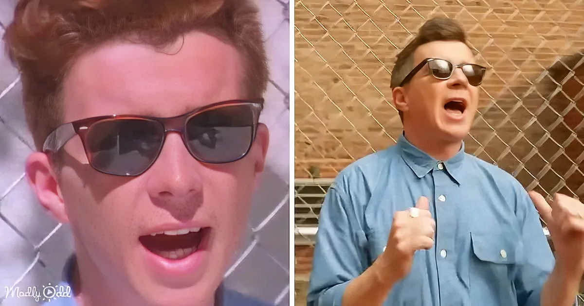 A man in a blue shirt and sunglasses stands in front of a chain-link fence, making a fist and appearing to shout.