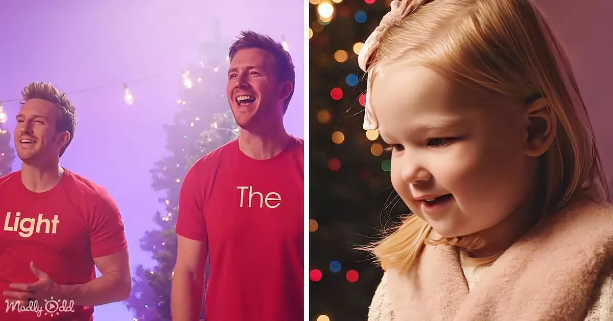 A man in a red shirt with "The Light" on it stands beside a child in a festive setting with Christmas lights.