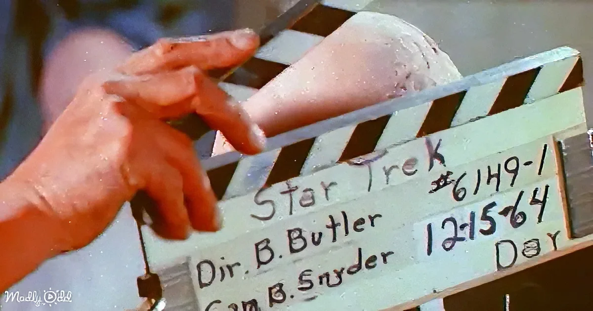 A hand holds a clapperboard labeled "Star Trek" with filming details.