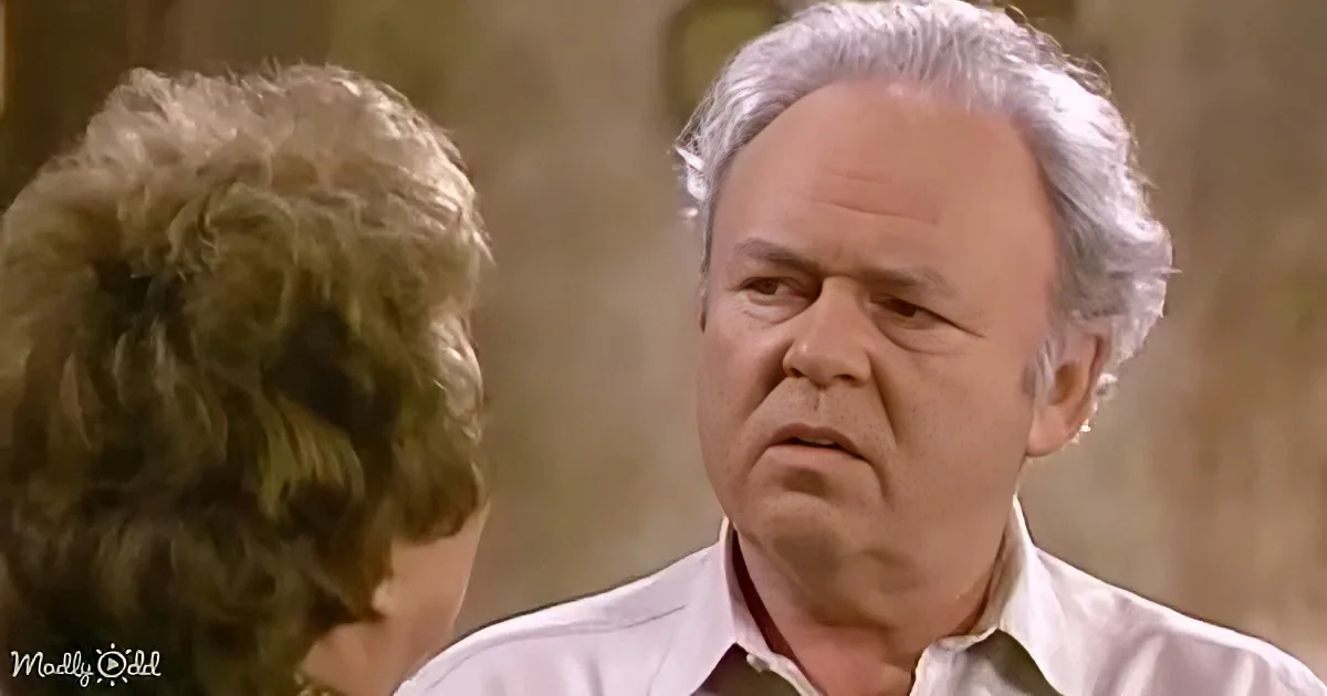 A man with white hair and a white shirt looks concerned at a woman with curly brown hair.
