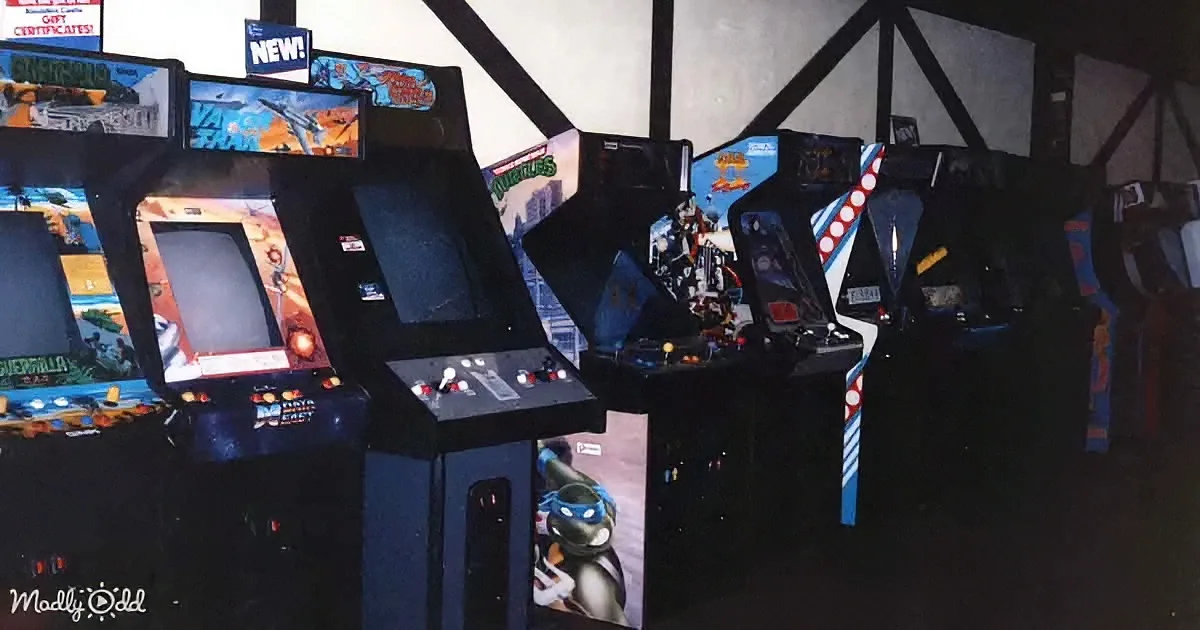 Arcade machines with colorful displays and control panels are lined up in a row.