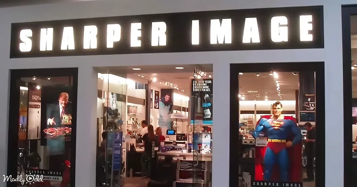 A Sharper Image store displays a Superman figure and various gadgets inside.
