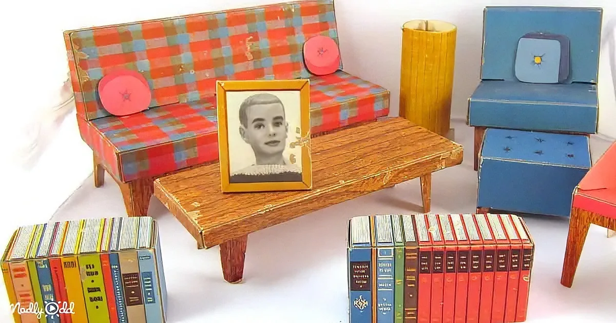 A miniature living room setup with a checkered sofa, wooden coffee table, and bookshelves.
