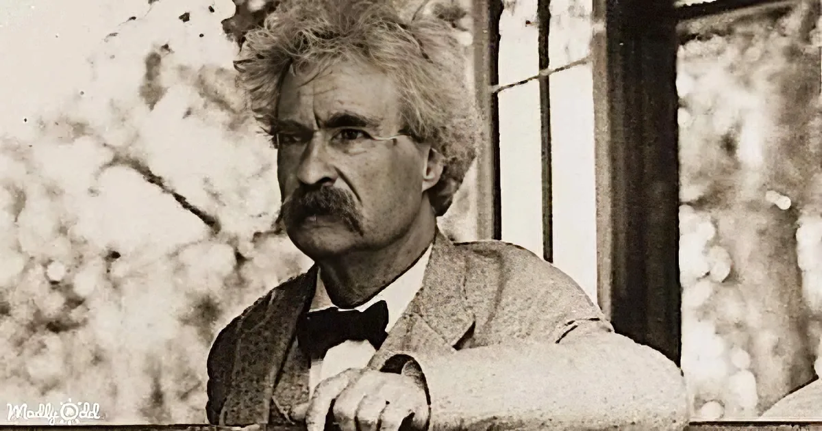 Mark Twain, wearing a suit and bow tie, leans on a railing, gazing thoughtfully.