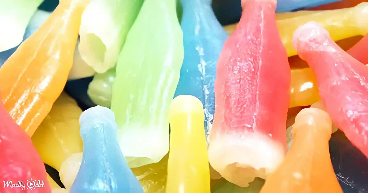 Colorful, glossy, candy-like objects resembling small, elongated shapes in various bright hues.