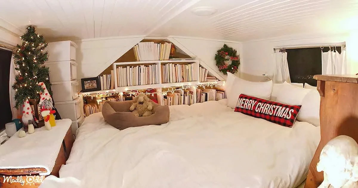 A cozy bedroom decorated for Christmas with a bed, bookshelf, and festive ornaments.