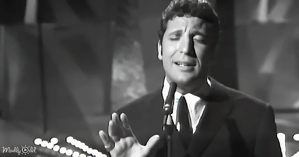 A man in a suit sings passionately into a microphone, his eyes closed, hands raised.