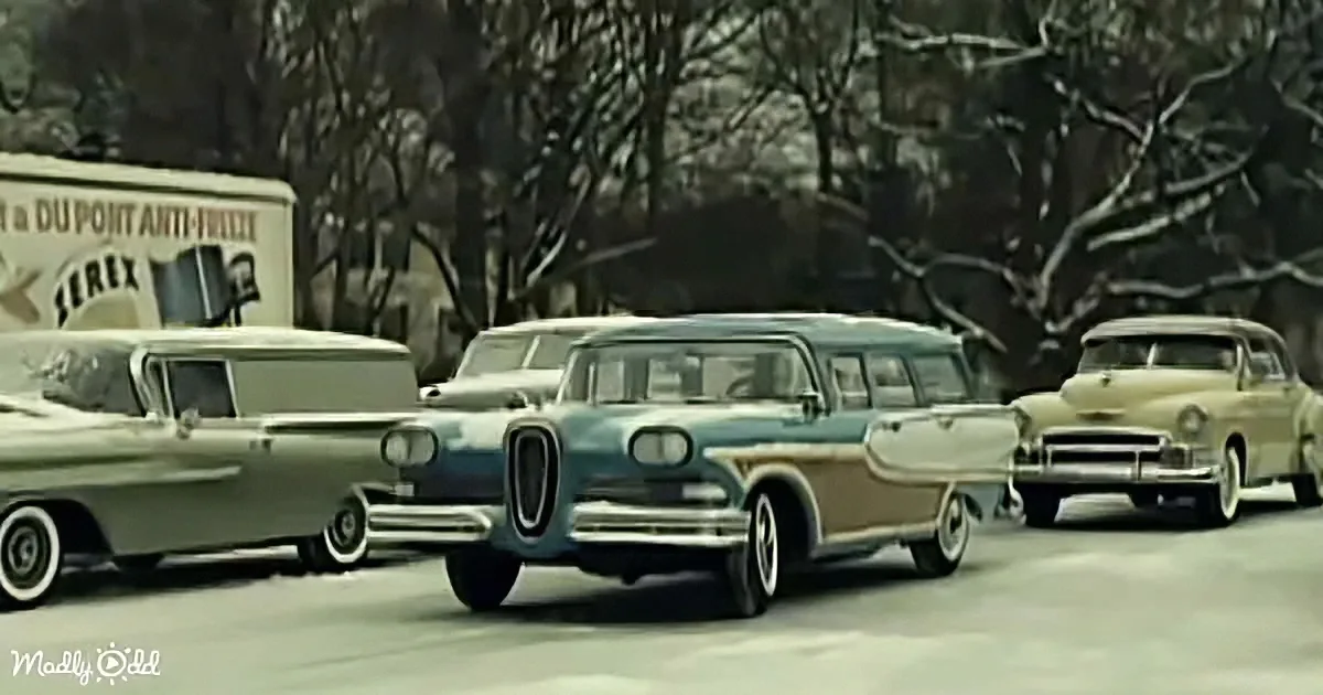 Vintage cars parked in a row, snow-covered trees in the background, old truck with "DuPont Anti-Freeze" sign.