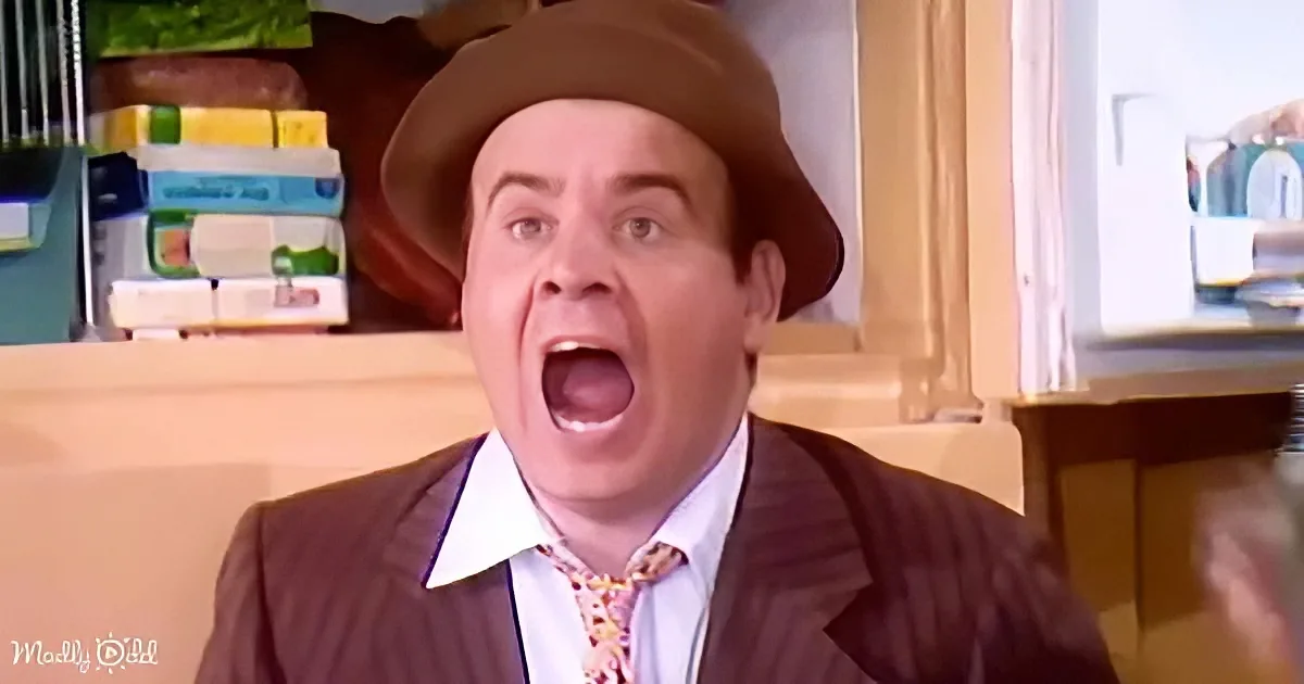 A man in a brown suit and hat is making a surprised or shocked expression.
