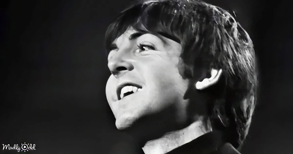 A smiling man with short, dark hair and a black-and-white background.