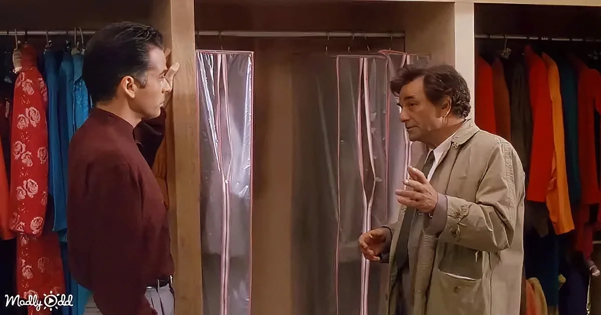 Two men in a clothing store, one gesturing, another listening, surrounded by colorful garments.