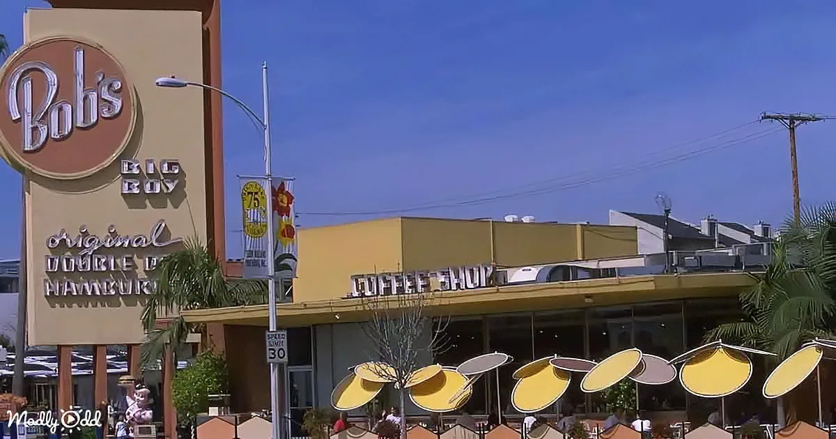 Bob's Big Boy restaurant sign with yellow and white umbrellas in front.