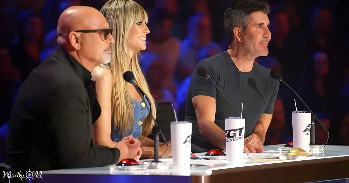 Three judges sit at a table with microphones and drinks, likely from a talent show.