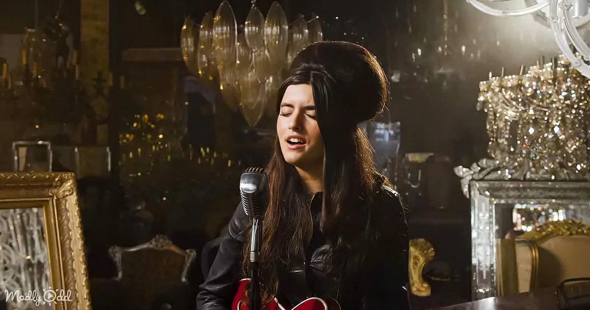 A woman sings into a microphone in a dimly lit room with ornate chandeliers and vintage decor.