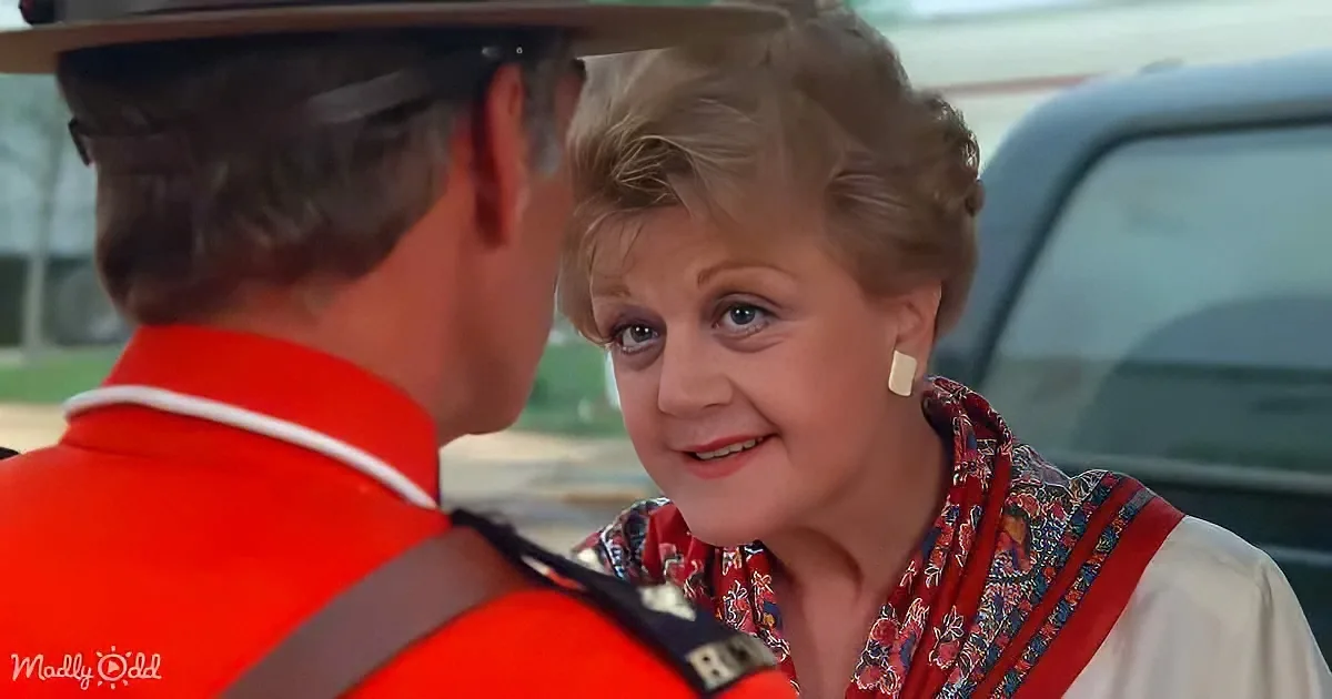 An older woman with short hair and a floral shirt smiles at a man in a red uniform with a hat.