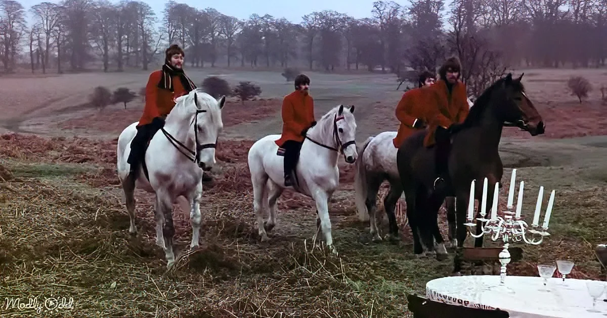 Four individuals in red coats ride horses near a table with a candelabra in a field.