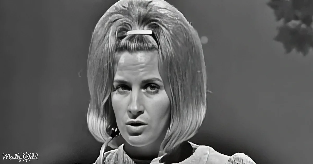 A woman with shoulder-length hair, wearing a white top, is shown in a black-and-white image.