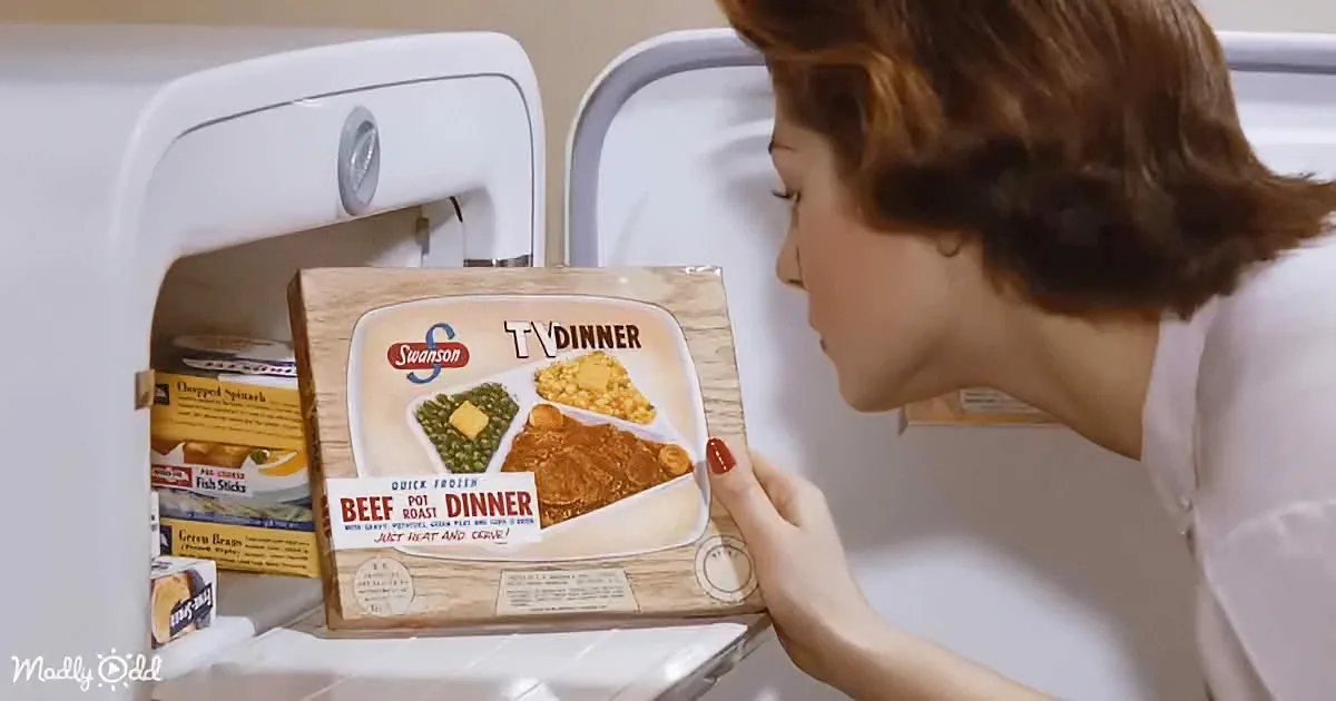 A woman examines a vintage Swanson TV Dinner box in a refrigerator.