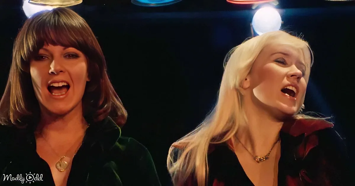 Two women with expressive faces, one with dark hair and the other with blonde hair, appear to be singing or reacting to...