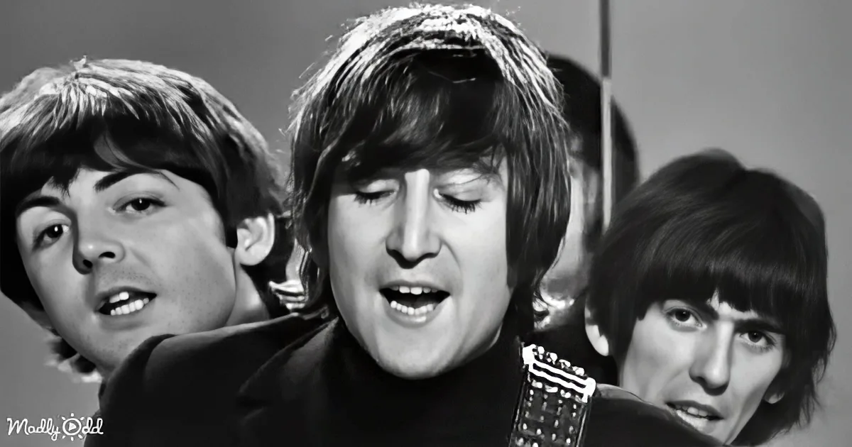A man with closed eyes singing, surrounded by other musicians, in a black-and-white image.