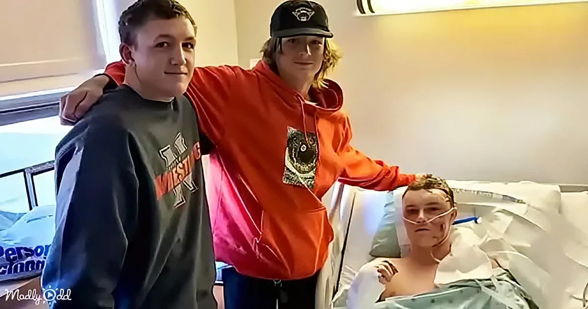 Three young men, one in a hospital bed with an oxygen mask, another in a red hoodie, and a third in a gray hoodie, pose...