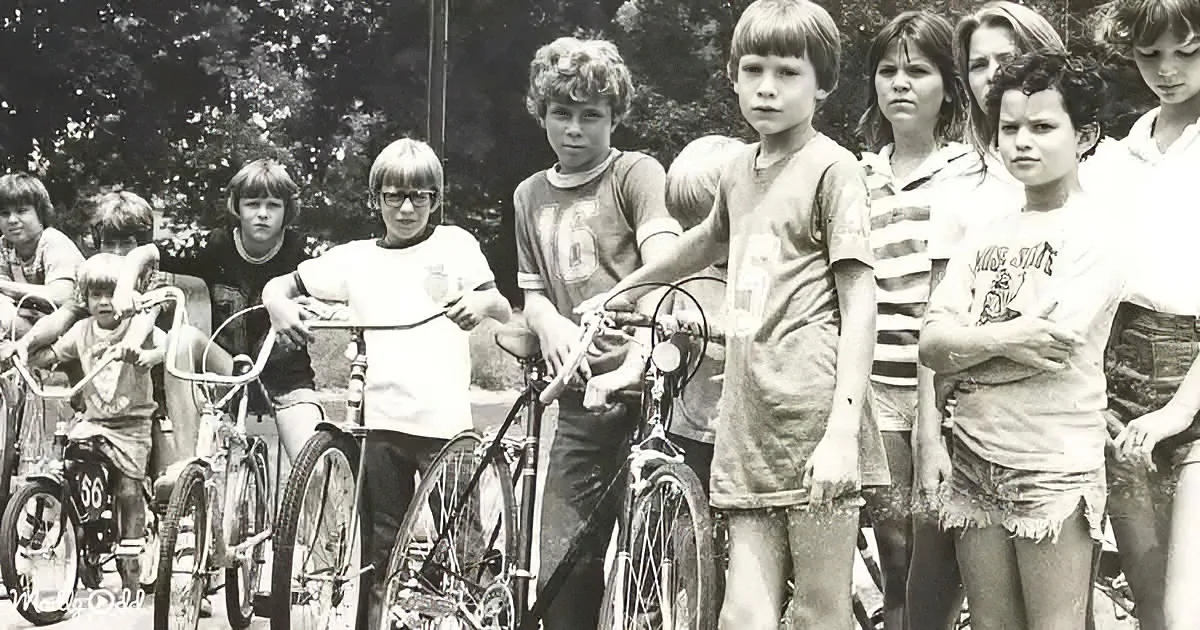 Children with bicycles, some muddy, standing outdoors in a group.