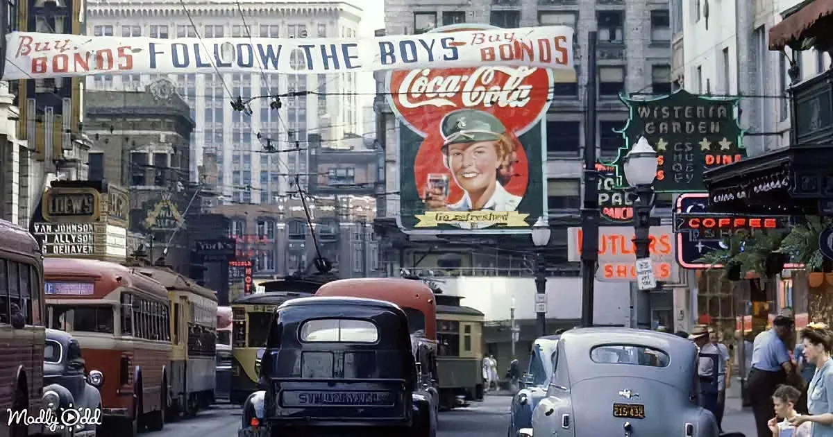 A bustling city street with vintage cars, trams, and a prominent Coca-Cola billboard.