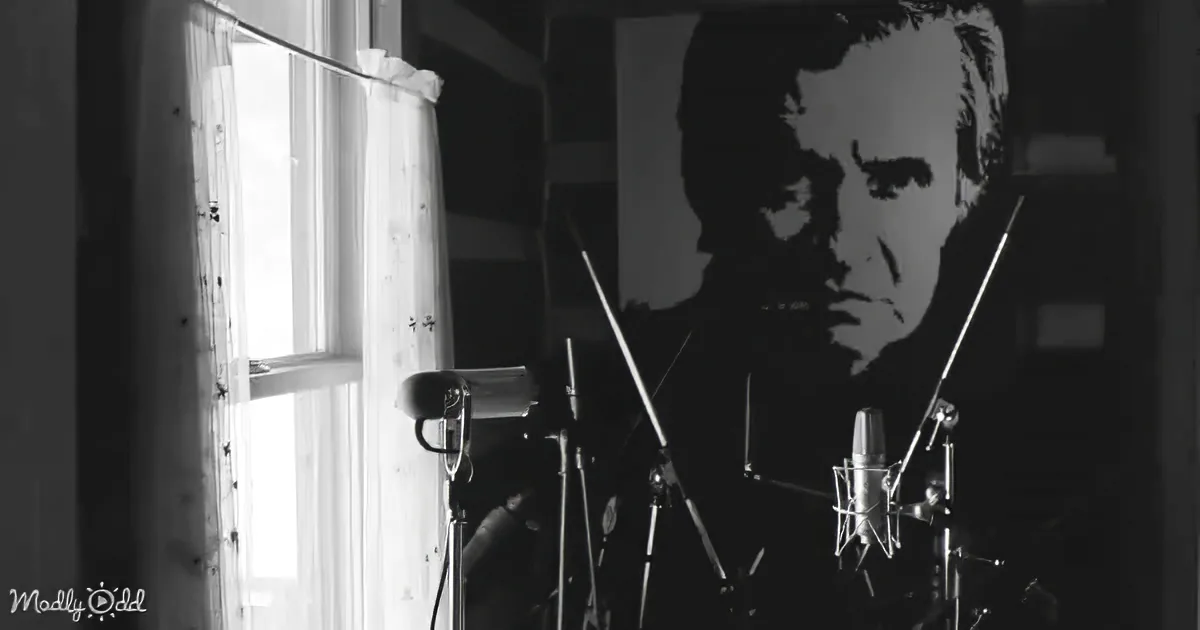 Microphones and a poster of a man in a dimly lit room with a window.